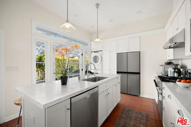 a kitchen with a sink a center island and stainless steel appliances
