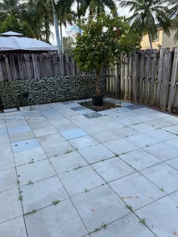 a view of backyard with potted plants and wooden fence
