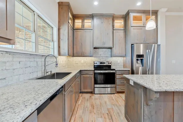 a kitchen with stainless steel appliances granite countertop a sink stove and refrigerator