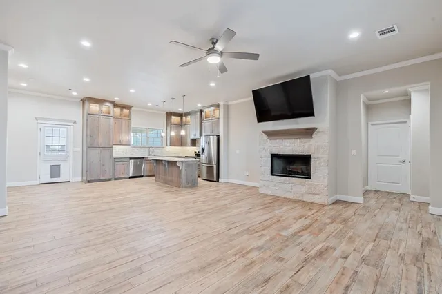 a view of an empty room with a kitchen and a fireplace