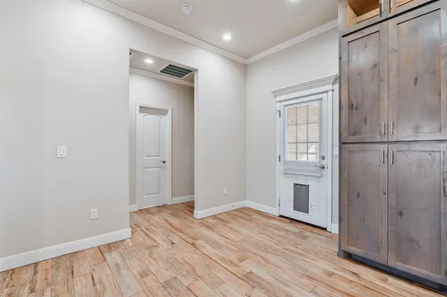 a view of empty room with wooden floor and cabinet