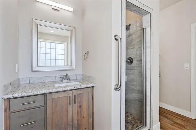 a bathroom with a granite countertop sink and a mirror