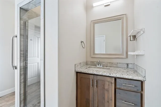 a bathroom with a granite countertop sink and a mirror