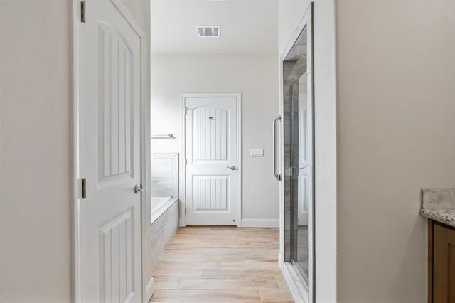 a view of a hallway with wooden floor