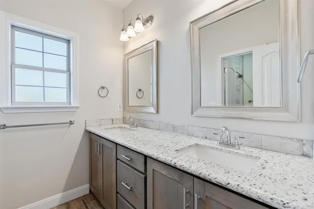 a bathroom with a granite countertop sink and a mirror