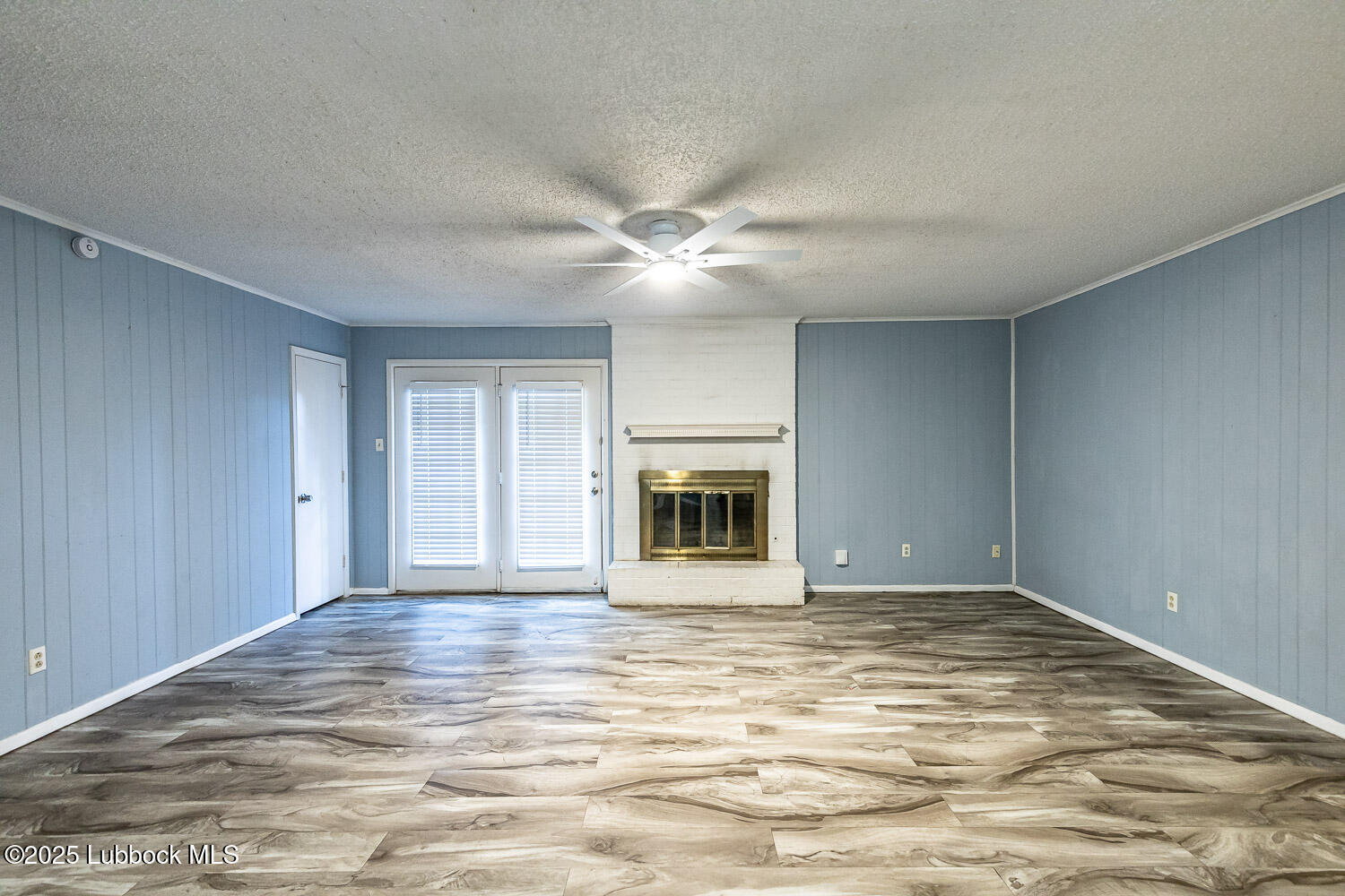 4305 52nd Street, Unit A Lubbock, TX 79413 - Photo 11 of 38 a view of an empty room with a fireplace and a window
