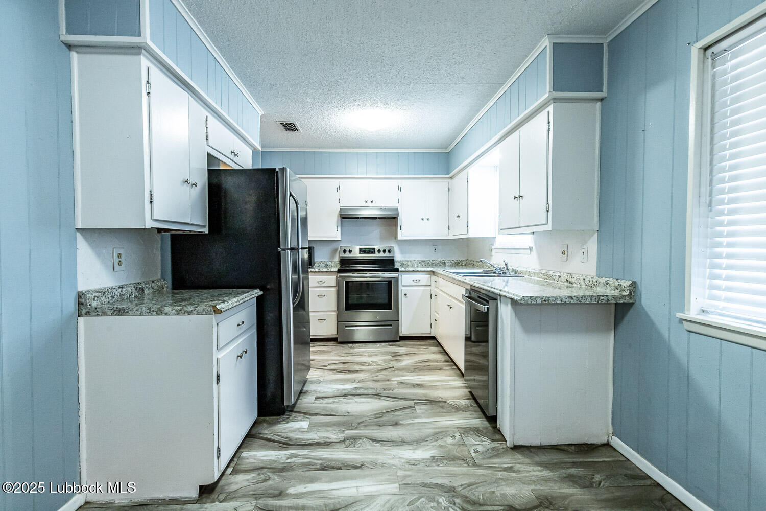 4305 52nd Street, Unit A Lubbock, TX 79413 - Photo 17 of 38 a kitchen with a sink a stove a refrigerator and cabinets