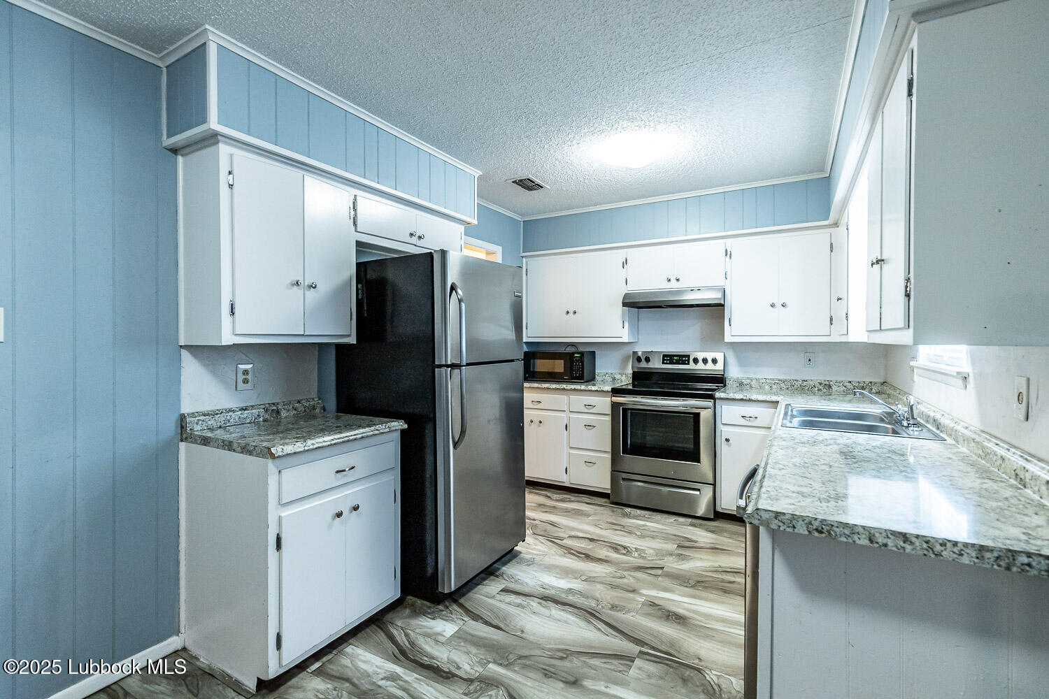 4305 52nd Street, Unit A Lubbock, TX 79413 - Photo 18 of 38 a kitchen with granite countertop a refrigerator oven a sink and cabinets