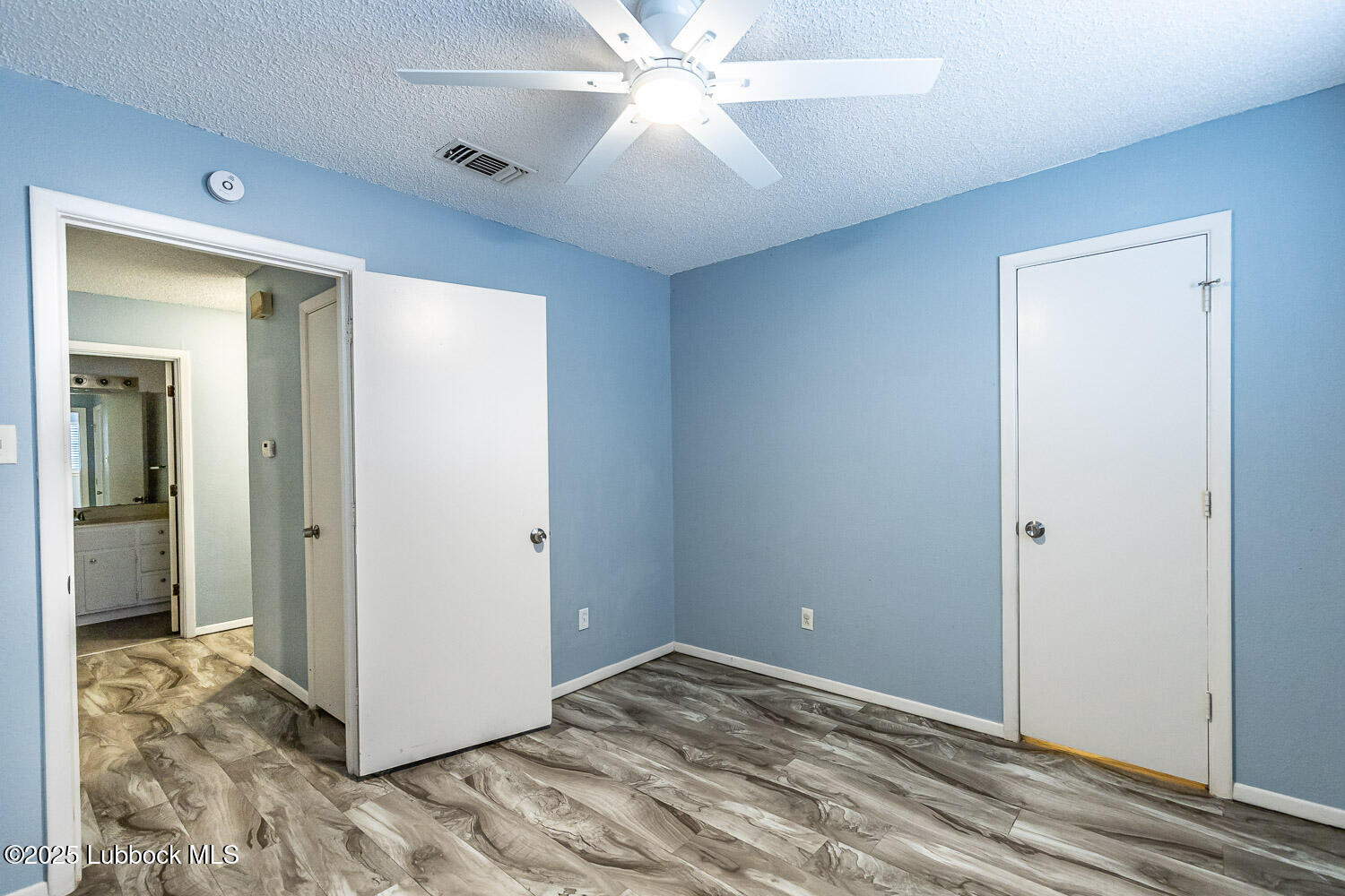 4305 52nd Street, Unit A Lubbock, TX 79413 - Photo 30 of 38 a view of a room with a ceiling fan and wooden floor