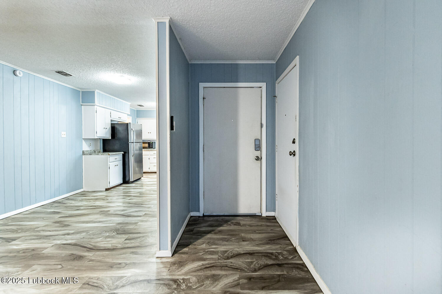 4305 52nd Street, Unit A Lubbock, TX 79413 - Photo 9 of 38 a view of a kitchen with wooden floor and a refrigerator