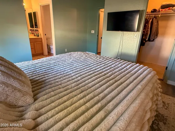 a bedroom with a bed and a flat screen tv