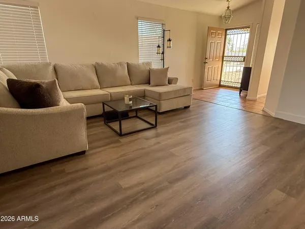 a living room with furniture and wooden floor
