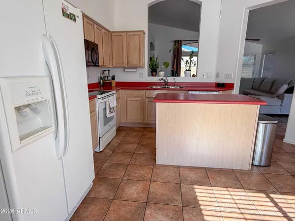 a kitchen with a sink a refrigerator and cabinets