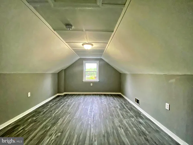 a view of empty room with window and wooden floor