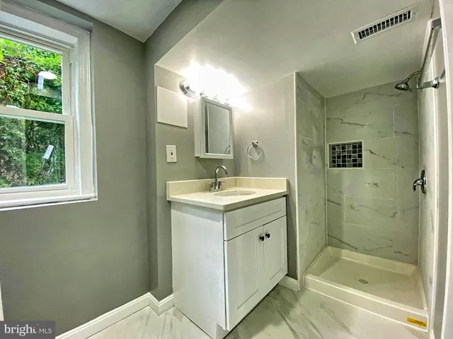 a bathroom with a shower sink and mirror