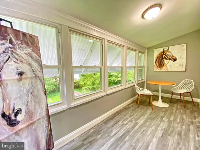 a view of a workspace with wooden floor and a window