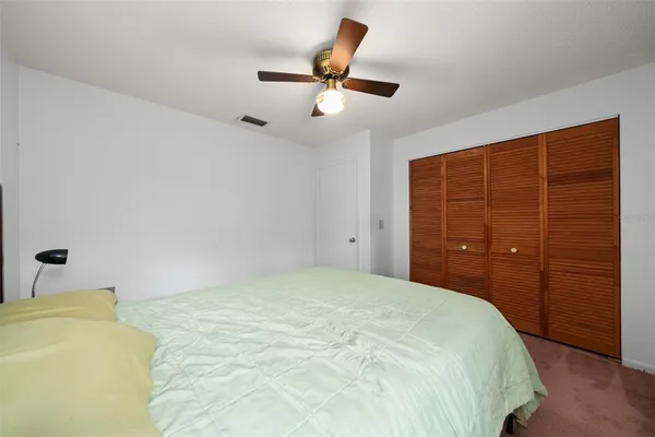 a bedroom with a bed and a ceiling fan