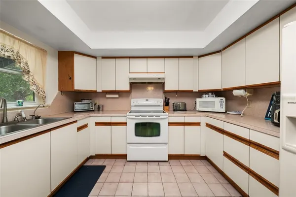 a kitchen with white cabinets and window