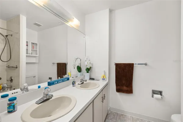 a bathroom with a sink double vanity granite tub shower and a mirror