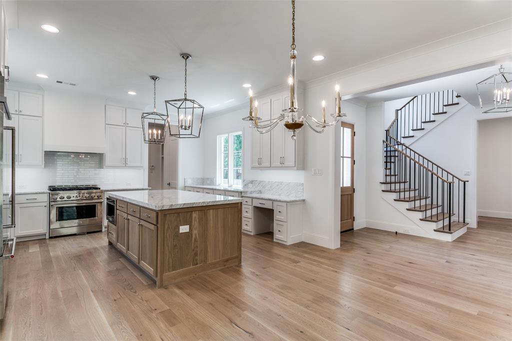 7519 Taos Road Dallas, TX 75209 - Photo 22 of 40 Kitchen featuring backsplash, appliances with stainless steel finishes, white cabinets, brown cabinets, and recessed lighting