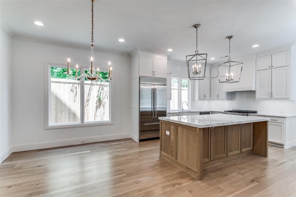 7519 Taos Road Dallas, TX 75209 - Photo 26 of 40 Kitchen featuring a chandelier, white cabinets, brown cabinetry, a center island, and recessed lighting