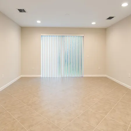 an empty room with a fan & windows
