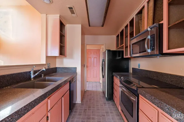 a kitchen with stainless steel appliances granite countertop a sink stove and cabinets