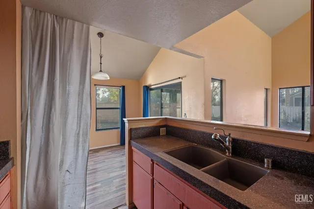 a kitchen with granite countertop a sink and a refrigerator