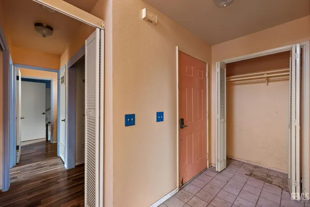 a view of a hallway with wooden floor and closet