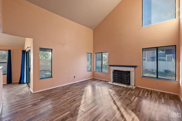 an empty room with window and fireplace