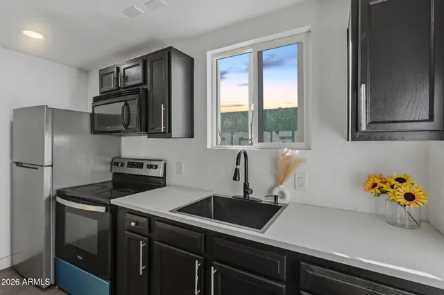 a kitchen with stainless steel appliances a sink a stove and a refrigerator