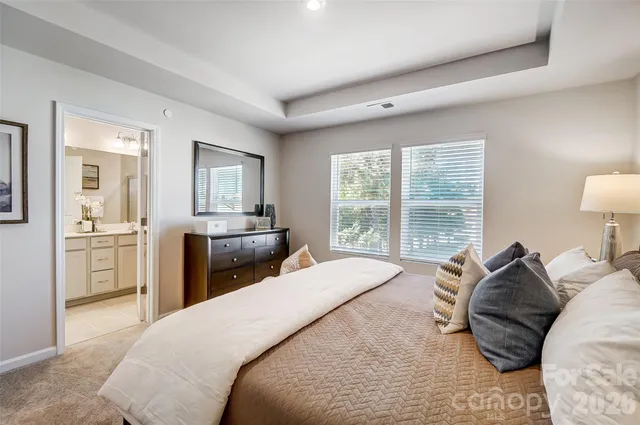 a bedroom with a bed and a view of living room