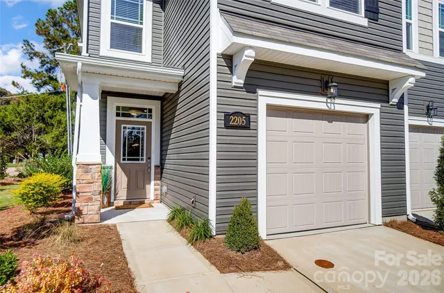 a view of a house with a door and a tree