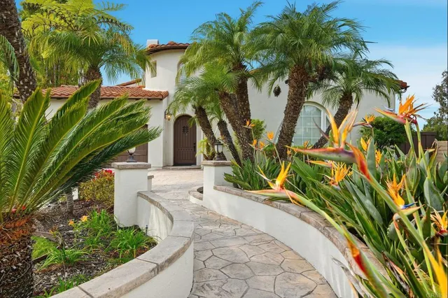 a view of a house with a yard and potted plants