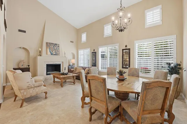 a dining room with furniture a large window and a chandelier