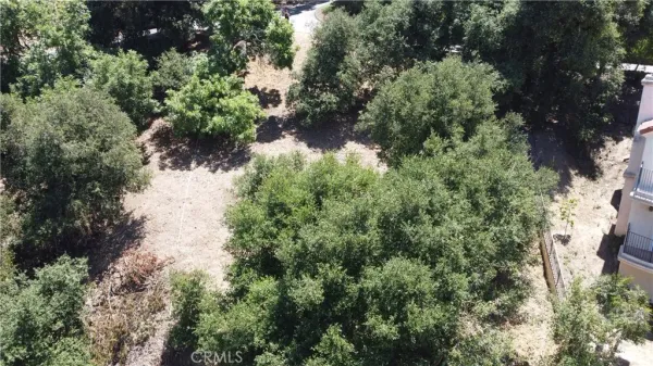 an aerial view of residential house with outdoor space and trees all around