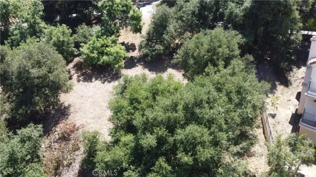 an aerial view of residential house with outdoor space and trees all around