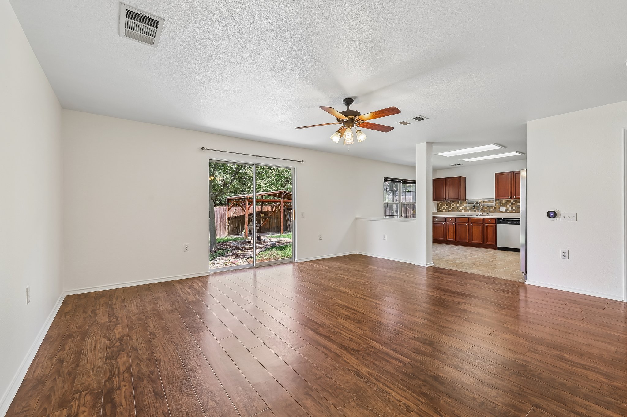 7658 Marble Ridge Drive Austin, TX 78747 - Photo 8 of 34 a view of an empty room with wooden floor and a window