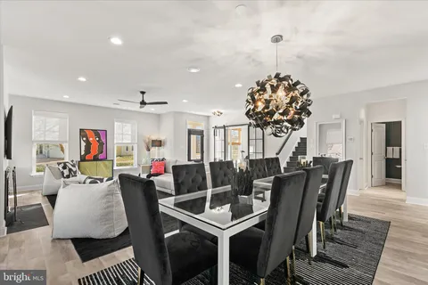 a living room with furniture a dining table and a potted plant