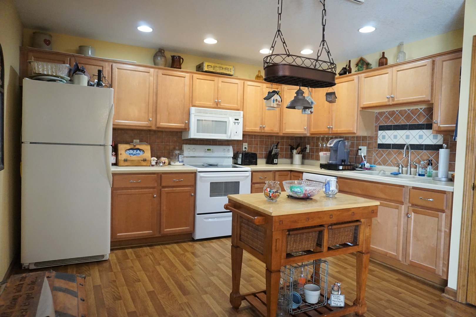 220 High Street Weldon, IL 61882 - Photo 12 of 33 a kitchen with stainless steel appliances granite countertop a refrigerator a sink dishwasher a stove and a dining table with wooden floor