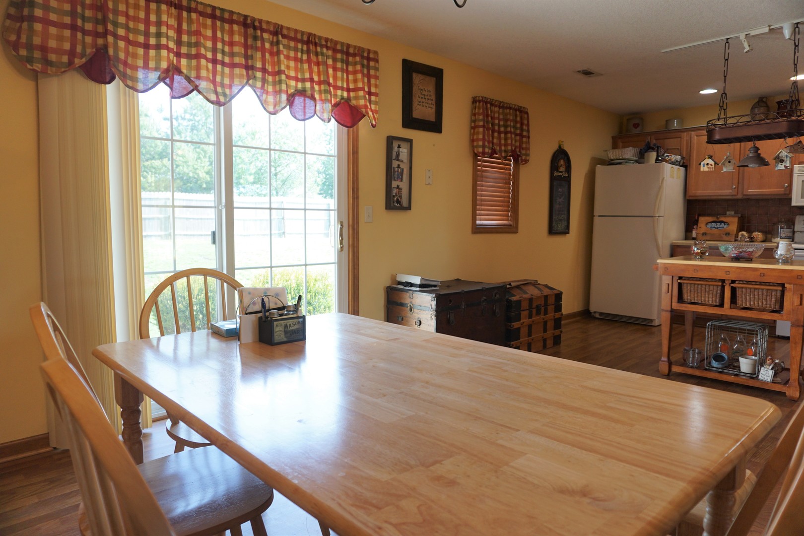 220 High Street Weldon, IL 61882 - Photo 16 of 33 a kitchen with stainless steel appliances granite countertop a stove a refrigerator a dining table and chairs with wooden floor