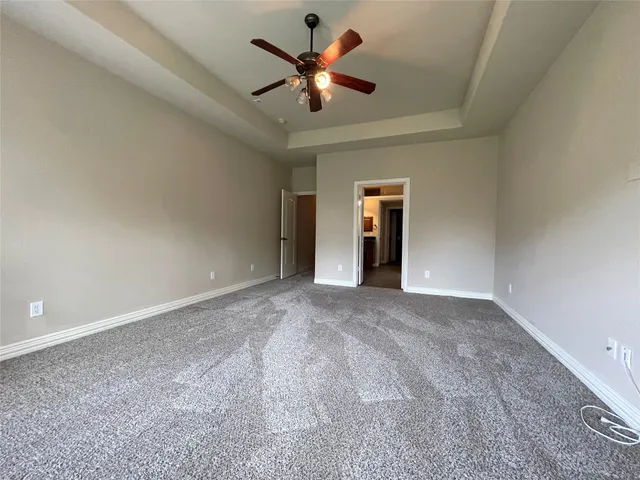 a view of an empty room and chandelier fan