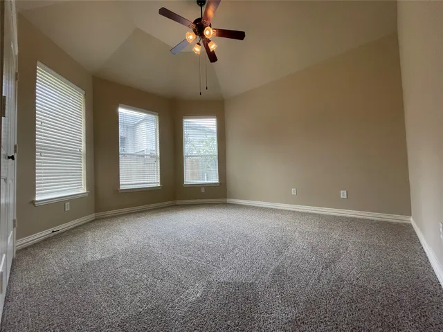 an empty room with windows and fan
