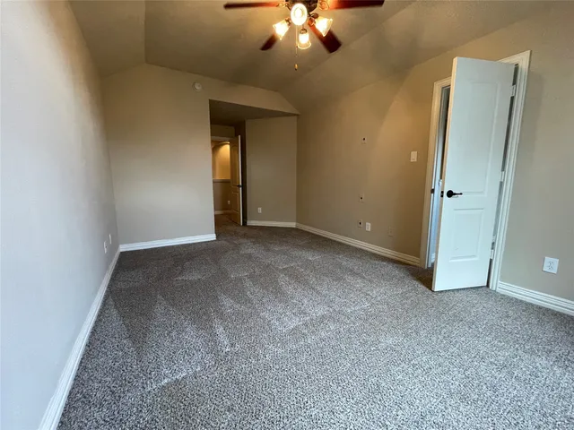 an empty room with closet and a chandelier fan