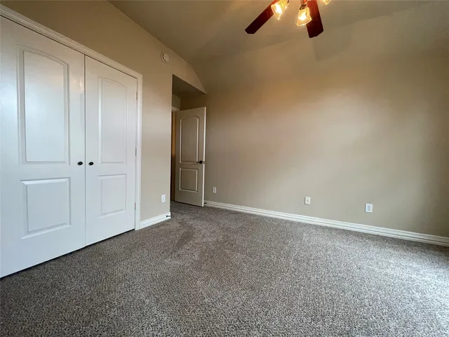 an empty room with closet and chandelier fan