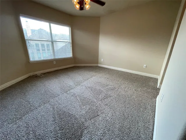 an empty room with windows and fireplace