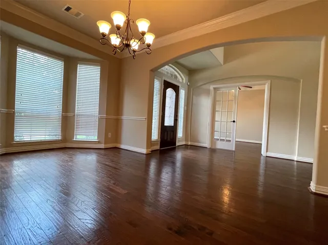 a view of a livingroom with a chandelier fan and windows