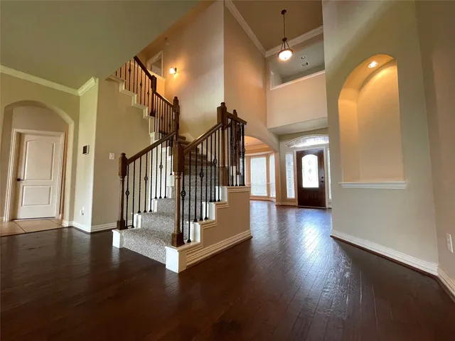 a view of a hallway with wooden floor and stairs
