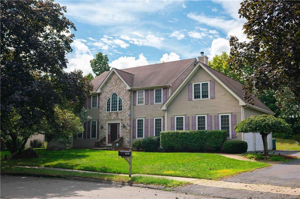 a front view of a house with a garden and yard