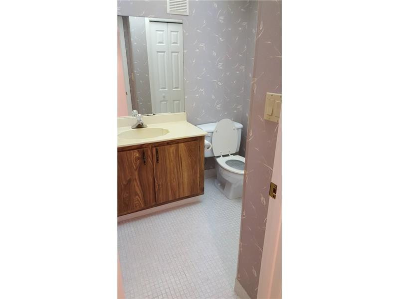 16251 Golf Club Road, Unit 210 Weston, FL 33326 - Photo 15 of 28 a bathroom with a sink a toilet and mirror
